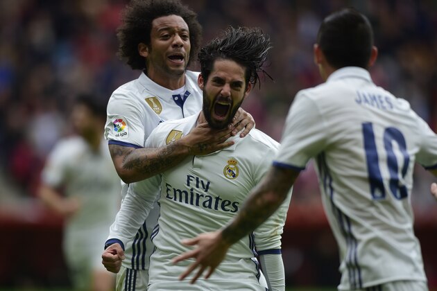 Real Madrid's midfielder Isco (C) celebrates with teammate Brazilian defender Marcelo after scoring a goal during the Spanish league football match Real Sporting de Gijon vs Real Madrid CF at El Molinon stadium in Gijon on April 15, 2017. / AFP PHOTO / MIGUEL RIOPA        (Photo credit should read MIGUEL RIOPA/AFP/Getty Images)