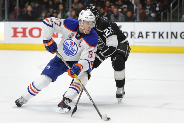 Edmonton Oilers center Connor McDavid (97) advances the puck as Los Angeles Kings center Trevor Lewis (22) defends in the third period of an NHL hockey game, Tuesday, April 4, 2017, in Los Angeles. The Kings won 6-4. (AP Photo/Michael Owen Baker)