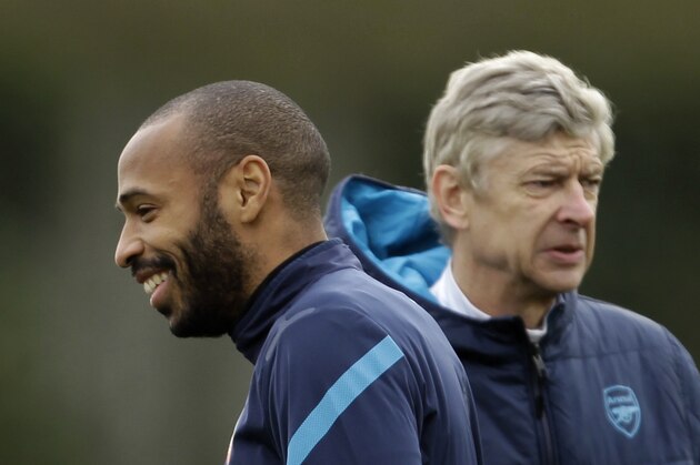 Arsenal's on loan former player, and the club's all time highest scorer, Thierry Henry, left, stands near the club's French manager Arsene Wenger during a training session at the club's facilities in London Colney, England, Tuesday, Feb. 14, 2012.  Arsenal are due to play AC Milan in the first leg of their Champions League last 16 soccer match in Milan on Wednesday.  (AP Photo/Matt Dunham)