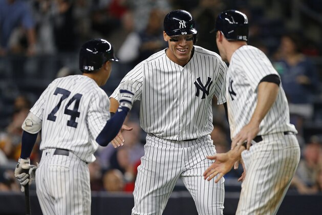New York Yankees' Ronald Torreyes (74) congratulates Aaron Judge and Chase Headley (12) who both scored on a double by Austin Romine against the St. Louis Cardinals during the eighth inning of a baseball game Sunday, April 16, 2017 at Yankee Stadium in New York. (AP Photo/Rich Schultz)