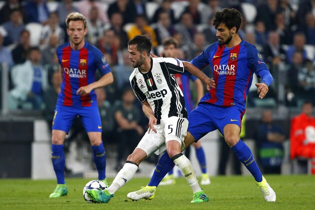 Juventus midfielder Miralem Pjanic (C) vies with Barcelona's Portuguese midfielder Andre Gomes during the UEFA Champions League quarter final first leg football match Juventus vs Barcelona, on April 11, 2017 at the Juventus stadium in Turin.  / AFP PHOTO / Marco BERTORELLO        (Photo credit should read MARCO BERTORELLO/AFP/Getty Images)