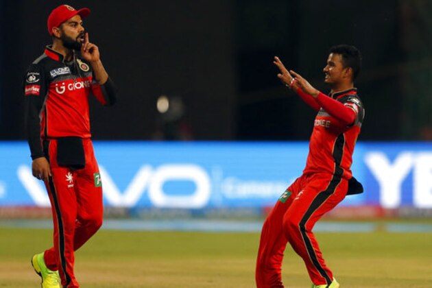 Royal Challengers Bangalore bowler Pawan Negi, right, celebrates with captain Virat Kohli the dismissal of Rising Pune Supergiants Rahul Tripathi during their Indian Premier League (IPL) cricket match in Bangalore, India, Sunday, April 16, 2017. (AP Photo/Aijaz Rahi)