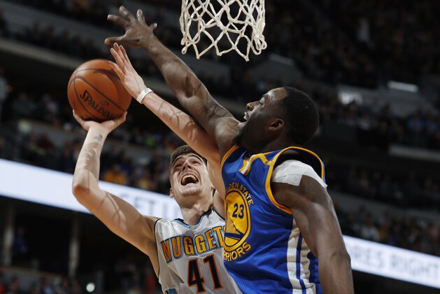 Golden State Warriors forward Draymond Green, front, blocks a shot by Denver Nuggets forward Juancho Hernangomez, of Spain, in the second half of an NBA basketball game, Monday, Feb. 13, 201, in Denver. The Nuggets won 132-110. (AP Photo/David Zalubowski)