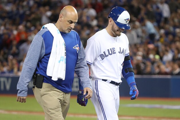 TORONTO, ON - APRIL 13: Josh Donaldson #20 of the Toronto Blue Jays exits the game with trainer George Poulos after hitting an RBI double in the sixth inning during MLB game action against the Baltimore Orioles at Rogers Centre on April 13, 2017 in Toronto, Canada. (Photo by Tom Szczerbowski/Getty Images)
