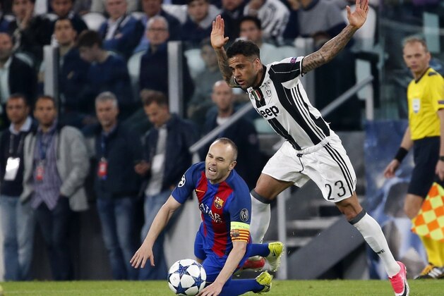 Juventus's Dani Alves, right, challenges Barcelona's Andres Iniesta during a Champions League, quarterfinal, first-leg soccer match between Juventus and Barcelona, at the Juventus Stadium in Turin, Italy, Tuesday, April 11, 2017. (AP Photo/Antonio Calanni)