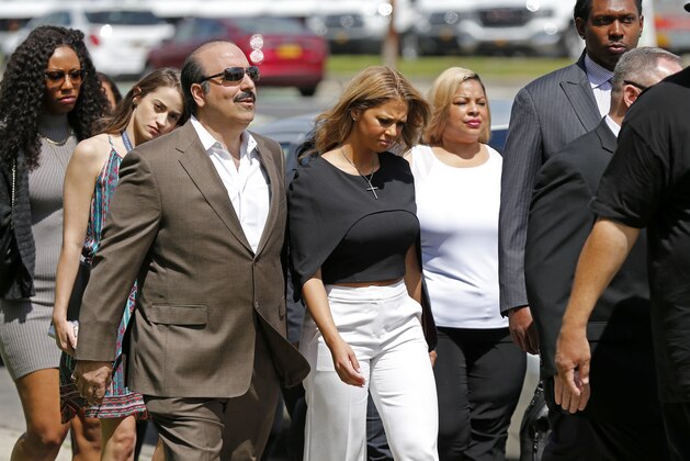 Racquel Smith, center, widow of former New Orleans Saints star Will Smith, arrives at the Orleans Parish criminal courthouse, Thursday, April 20, 2017, in New Orleans, with supporters, for the second day of a sentencing hearing for Cardell Hayes, who killed her husband and shot her, and was convicted of manslaughter. (AP Photo/Gerald Herbert)