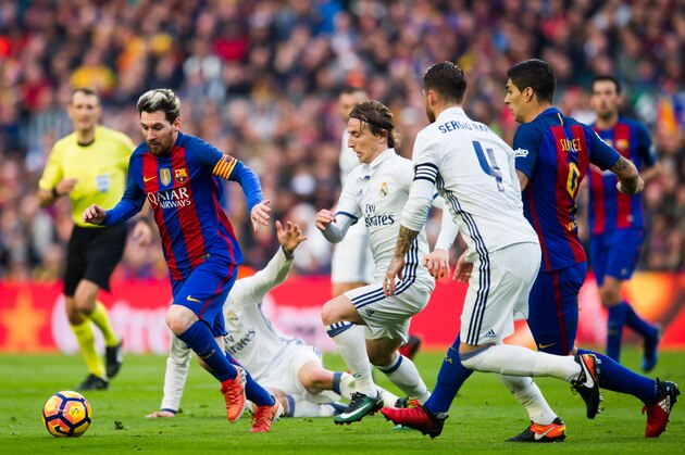 BARCELONA, SPAIN - DECEMBER 03: Lionel Messi (L) of FC Barcelona conducts the ball next to his teammate Luis Suarez (R) and Luka Modric (2nd L) and Sergio Ramos (2nd R) of Real Madrid CF during the La Liga match between FC Barcelona and Real Madrid CF at Camp Nou stadium on December 3, 2016 in Barcelona, Spain. (Photo by Alex Caparros/Getty Images)