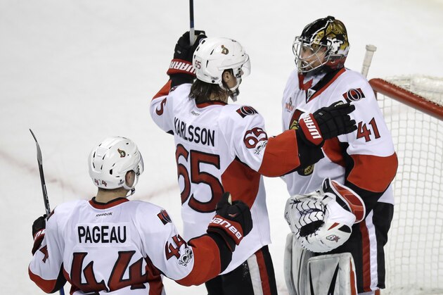 Ottawa Senators goalie Craig Anderson (41) is congratulated by Erik Karlsson (65) and Jean-Gabriel Pageau (44) after defeating the Boston Bruins 3-2 during an NHL hockey game in Boston, Tuesday, March 21, 2017. (AP Photo/Charles Krupa)