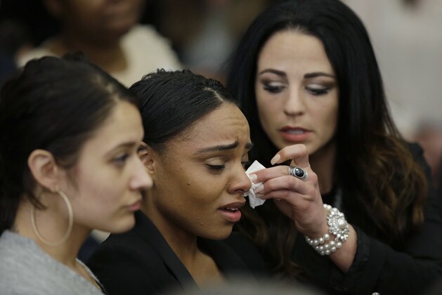 Shayanna Jenkins Hernandez, center,  the fiancee of former New England Patriots tight end Aaron Hernandez, is comforted as she reacts to Hernandez's double murder acquittal at Suffolk Superior Court Friday, April 14, 2017, in Boston. Hernandez stood trial for the July 2012 killings of Daniel de Abreu and Safiro Furtado, who he encountered in a Boston nightclub. The former NFL player is already serving a life sentence in the 2013 killing of semi-professional football player Odin Lloyd. (AP Photo/Stephan Savoia, Pool)