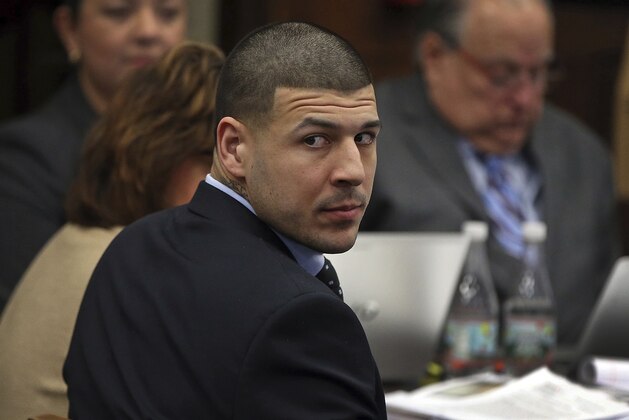 Former New England Patriots tight end Aaron Hernandez looks back during his double murder trial in Suffolk Superior Court in Boston, Wednesday, April 5, 2017.  Hernandez is standing trial for the July 2012 killings of Daniel de Abreu and Safiro Furtado, who he encountered in a Boston nightclub. The former NFL player is already serving a life sentence in the 2013 killing of semi-professional football player Odin Lloyd.  (Nancy Lane/The Boston Herald via AP, Pool)