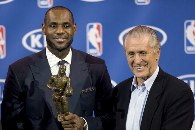 In this May 5, 2013 photo, Miami Heat NBA basketball player LeBron James, left, holds his NBA Most Valuable Player award as he poses with team president Pat Riley, in Miami. Before James makes his next decision, Riley will get a chance to convince him to stay in Miami. Two people familiar with the situation told The Associated Press late Sunday night, July 6, 2014, that James will meet with the Heat president this week before making a decision about where to play next season. (AP Photo/J Pat Carter)