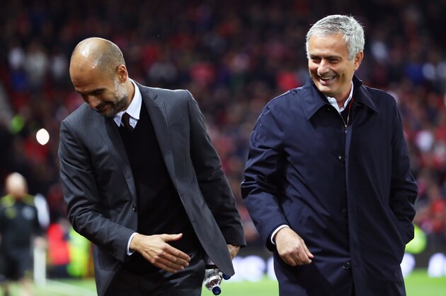 MANCHESTER, ENGLAND - OCTOBER 26: Josep Guardiola, Manager of Manchester City (L) and Jose Mourinho, Manager of Manchester United (R) share a joke prior to kick off during the EFL Cup fourth round match between Manchester United and Manchester City at Old Trafford on October 26, 2016 in Manchester, England.  (Photo by Michael Steele/Getty Images)