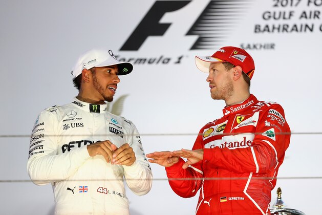 BAHRAIN, BAHRAIN - APRIL 16:  Top two finishers, race winner Sebastian Vettel of Germany and Ferrari and second placed Lewis Hamilton of Great Britain and Mercedes GP on the podium during the Bahrain Formula One Grand Prix at Bahrain International Circuit on April 16, 2017 in Bahrain, Bahrain.  (Photo by Clive Mason/Getty Images)
