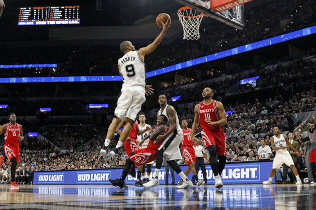 SAN ANTONIO,TX - MARCH 6: Tony Parker #9 of the San Antonio Spurs scores two as Patrick Beverley #2 of the Houston Rockets falls into the arms of LaMarcus Aldridge #12 of the San Antonio Spursat AT&T Center on March 6, 2017 in San Antonio, Texas.  NOTE TO USER: User expressly acknowledges and agrees that , by downloading and or using this photograph, User is consenting to the terms and conditions of the Getty Images License Agreement. (Photo by Ronald Cortes/Getty Images)