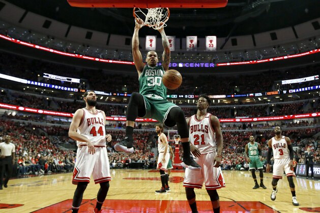 Boston Celtics' Gerald Green (30) dunks as Chicago Bulls' Nikola Mirotic, left, and Jimmy Butller react during the first half in Game 6 of an NBA basketball first-round playoff series, Friday, April. 28, 2017, in Chicago. (AP Photo/Nam Y. Huh)