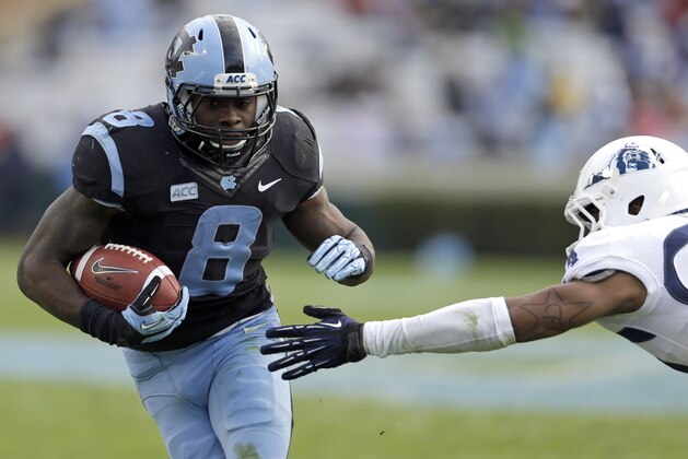 North Carolina's T.J. Logan (8) runs the ball as Old Dominion's Fellonte Misher reaches for the tackle during the second half of an NCAA college football game in Chapel Hill, N.C., Saturday, Nov. 23, 2013. North Carolina won 80-20. (AP Photo/Gerry Broome)