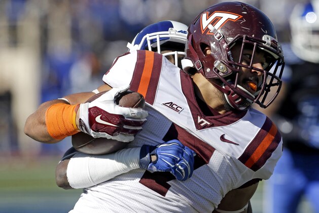 Virginia Tech's Bucky Hodges (7) runs the ball as Duke's Breon Borders tackles him from behind during the first half of an NCAA college football game in Durham, N.C., Saturday, Nov. 15, 2014. (AP Photo/Gerry Broome)