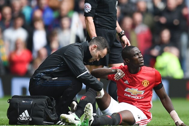 Manchester United's Ivorian defender Eric Bailly (R) gets attention on the pitch for an injury during the English Premier League football match between Manchester United and Swansea City at Old Trafford in Manchester, north west England, on April 30, 2017. / AFP PHOTO / Oli SCARFF / RESTRICTED TO EDITORIAL USE. No use with unauthorized audio, video, data, fixture lists, club/league logos or 'live' services. Online in-match use limited to 75 images, no video emulation. No use in betting, games or single club/league/player publications.  /         (Photo credit should read OLI SCARFF/AFP/Getty Images)