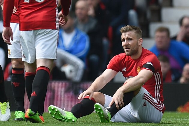 Manchester United's English defender Luke Shaw (R) sits injured on the pitch during the English Premier League football match between Manchester United and Swansea City at Old Trafford in Manchester, north west England, on April 30, 2017. / AFP PHOTO / Oli SCARFF / RESTRICTED TO EDITORIAL USE. No use with unauthorized audio, video, data, fixture lists, club/league logos or 'live' services. Online in-match use limited to 75 images, no video emulation. No use in betting, games or single club/league/player publications.  /         (Photo credit should read OLI SCARFF/AFP/Getty Images)