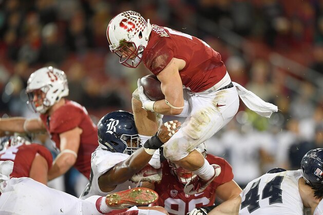 PALO ALTO, CA - NOVEMBER 26:  Christian McCaffrey #5 of the Stanford Cardinal leaps over the line for a three yard gain and a first down against the Rice Owls in the first quarter of their NCAA football game at Stanford Stadium on November 26, 2016 in Palo Alto, California.  (Photo by Thearon W. Henderson/Getty Images)