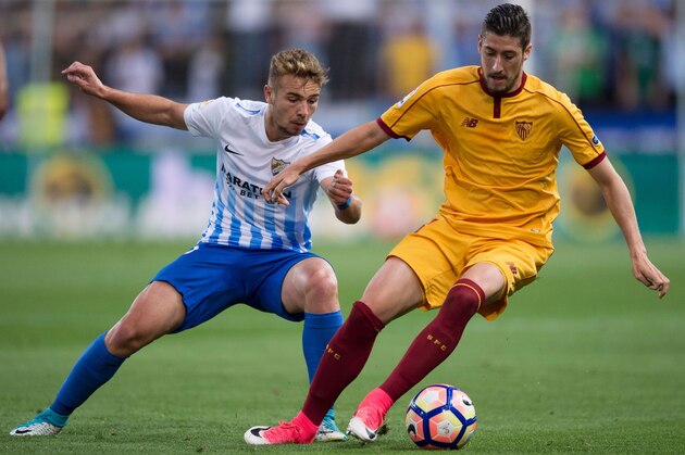 Malaga's midfielder Javier Ontiveros (L) vies with Sevilla's defender Sergio Escudero during the Spanish league football match Malaga CF vs Sevilla FC at La Rosaleda stadium in Malaga on May 1, 2017. / AFP PHOTO / JORGE GUERRERO        (Photo credit should read JORGE GUERRERO/AFP/Getty Images)