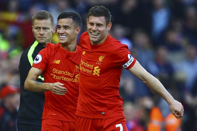 Liverpool's Brazilian midfielder Philippe Coutinho (L) celebrates with Liverpool's English midfielder James Milner after scoring during the English Premier League football match between Liverpool and Crystal Palace at Anfield in Liverpool, north west England on April 23, 2017. / AFP PHOTO / Geoff CADDICK / RESTRICTED TO EDITORIAL USE. No use with unauthorized audio, video, data, fixture lists, club/league logos or 'live' services. Online in-match use limited to 75 images, no video emulation. No use in betting, games or single club/league/player publications.  /         (Photo credit should read GEOFF CADDICK/AFP/Getty Images)
