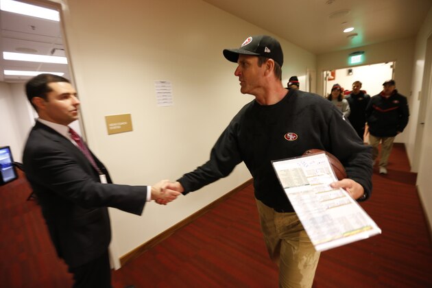 SANTA CLARA, CA - DECEMBER 20: CEO Jed York of the San Francisco 49ers shakes hands with Head Coach Jim Harbaugh in the hallway following the game against the Arizona Cardinals at Levi Stadium on December 28, 2014 in Santa Clara, California. The 49ers defeated the Cardinals 20-17. (Photo by Michael Zagaris/San Francisco 49ers/Getty Images)