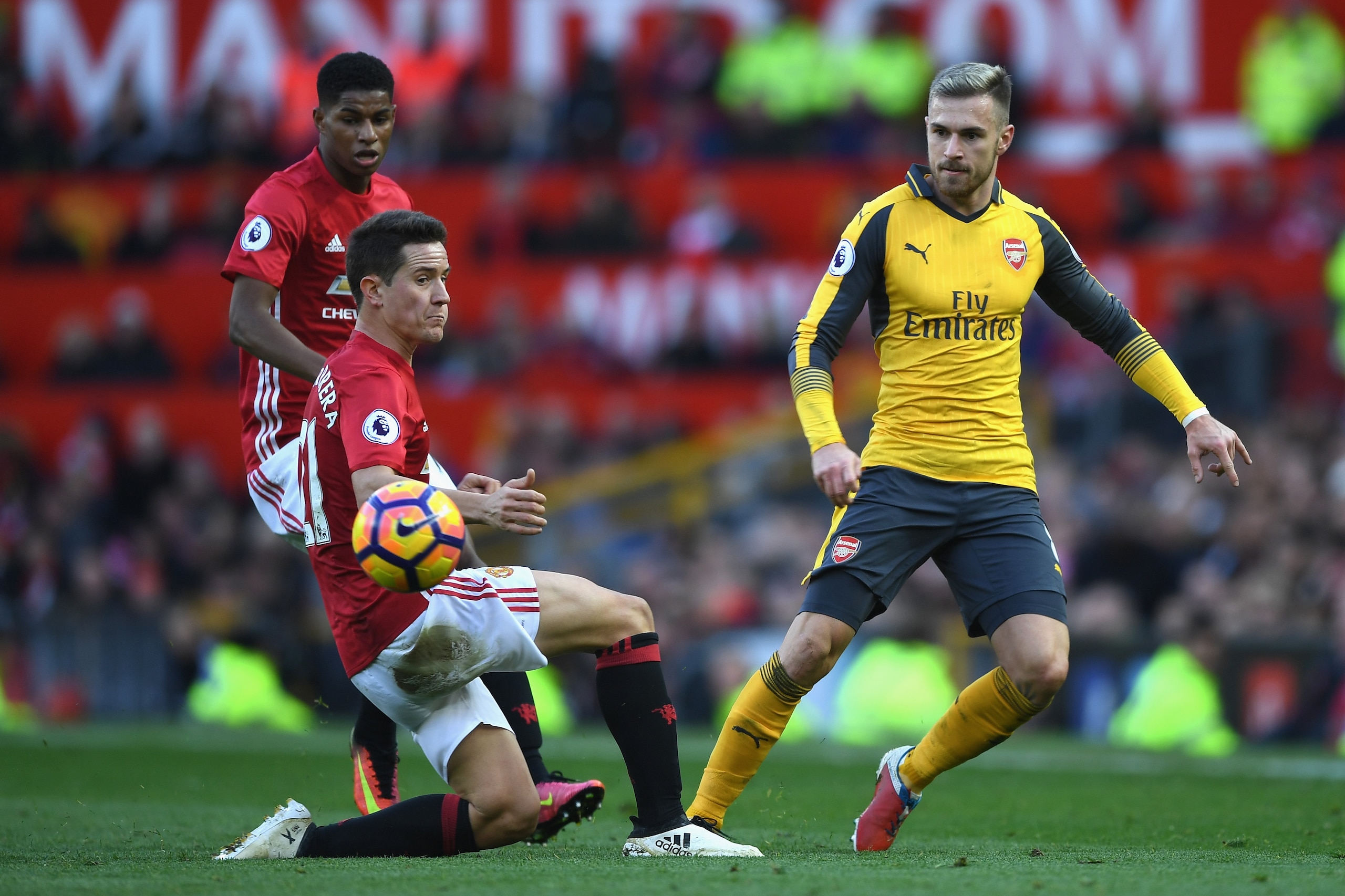 MANCHESTER, ENGLAND - NOVEMBER 19:  Aaron Ramsey of Arsenal (R) passes the ball past Ander Herrera of Manchester United (L) during the Premier League match between Manchester United and Arsenal at Old Trafford on November 19, 2016 in Manchester, England.  (Photo by Shaun Botterill/Getty Images)
