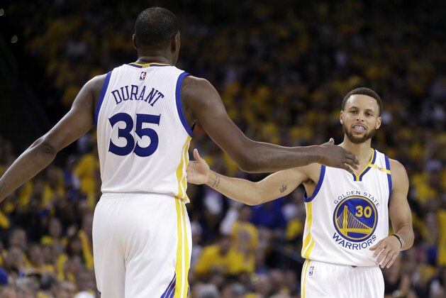 Golden State Warriors' Stephen Curry, right, shakes hands with teammate Kevin Durant (35) during the first half in Game 2 of an NBA basketball second-round playoff series against the Utah Jazz, Thursday, May 4, 2017, in Oakland, Calif. (AP Photo/Marcio Jose Sanchez)