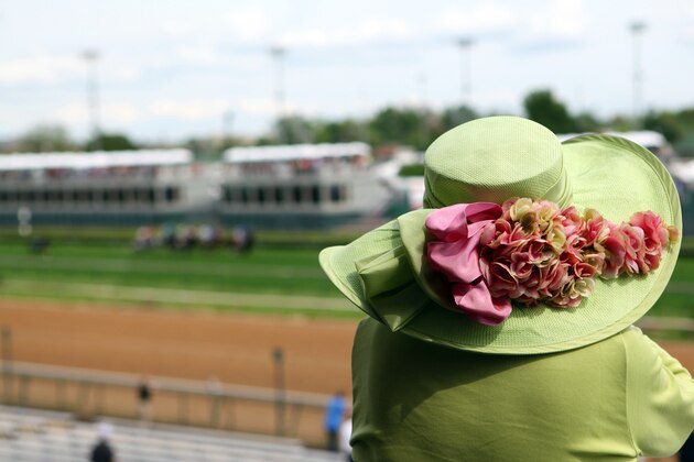 A fan with a fancy hat watches a turf race at Churchill Downs Thursday, May 2, 2013, in Louisville, Ky. Saturday will be the 139th running of the Kentucky Derby. (AP Photo/Gregory Payan)