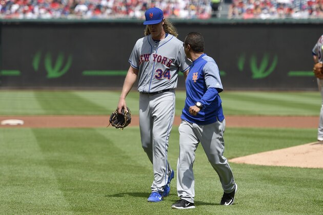 El abridor Noah Syndergaard (34), de los Mets de Nueva York, sale del partido ante los Nacionales de Washington en el segundo inning por lesión, el domingo 30 de abril de 2017, en Washington. (AP Foto/Nick Wass)
