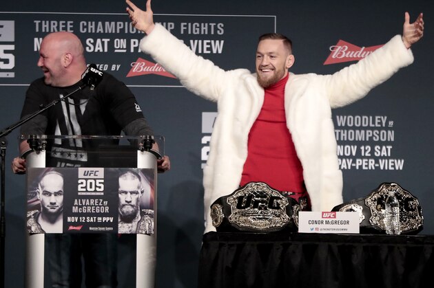 Conor McGregor, center, reacts after taking his opponent Eddie Alvarez's title from a table to put it on his side during a news conference ahead of the UFC 205 mixed martial arts fights, Thursday, Nov. 10, 2016, at Madison Square Garden in New York as UFC president Dana White, left, and fighter Stephen Thompson, right, react. McGregor and Alvarez will fight each other while Thompson will fight Tyron Woodley on Saturday. (AP Photo/Julio Cortez)