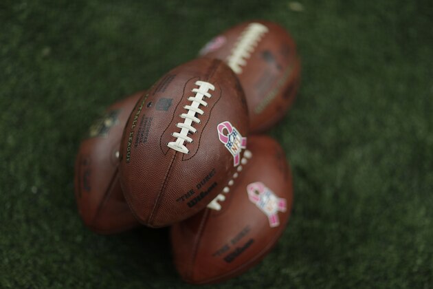Footballs lie on the turf with Breast Cancer Awareness Logos before the first of an NFL football game between the Atlanta Falcons and the Green Bay Packers, Sunday, Oct. 30, 2016, in Atlanta. (AP Photo/David Goldman)