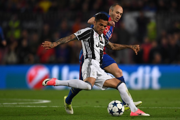 BARCELONA, SPAIN - APRIL 19: Dani Alves of Juventus and Andres Iniesta of Barcelona compete for the ball during the UEFA Champions League Quarter Final second leg match between FC Barcelona and Juventus at Camp Nou on April 19, 2017 in Barcelona, Spain. (Photo by Etsuo Hara/Getty Images)