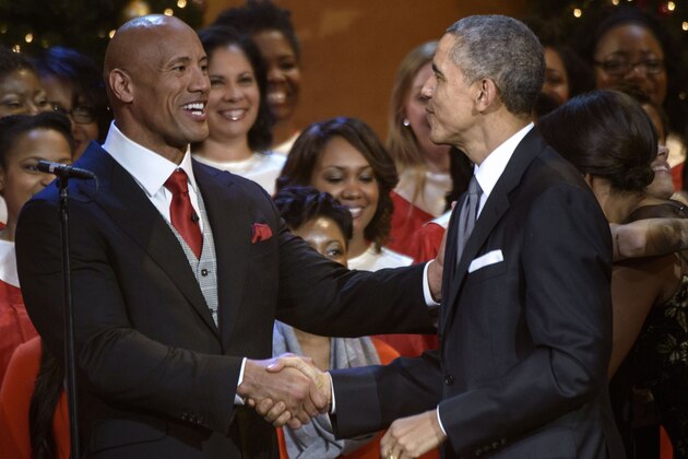 Dwayne 'The Rock' Johnson (L) and US President Barack Obama shake hands  during a taping of the Christmas in Washington concert at the National Building Museum December 14, 2014 in Washington, DC. Obama and the first family attended the charity concert to benefit the Children's National Medical Center. AFP PHOTO/BRENDAN SMIALOWSKI        (Photo credit should read BRENDAN SMIALOWSKI/AFP/Getty Images)