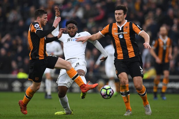 Swansea City's Dutch midfielder Leroy Fer (C) vies with Hull City's Scottish defender Andrew Robertson (L) and Hull City's English defender Harry Maguire during the English Premier League football match between Hull City and Swansea City at the KCOM Stadium in Kingston upon Hull, north east England on March 11, 2017.
Niasse scored both goals as Hull won the game 2-1. / AFP PHOTO / Paul ELLIS / RESTRICTED TO EDITORIAL USE. No use with unauthorized audio, video, data, fixture lists, club/league logos or 'live' services. Online in-match use limited to 75 images, no video emulation. No use in betting, games or single club/league/player publications.  /         (Photo credit should read PAUL ELLIS/AFP/Getty Images)