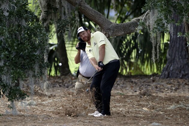 J.B. Holmes hits from under a tree near the second fairway during the third round of The Players Championship golf tournament Saturday, May 13, 2017, in Ponte Vedra Beach, Fla. (AP Photo/Chris O'Meara)