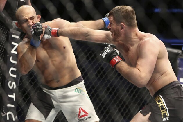 Stipe Miocic, lands a right against Junior Dos Santos in a mixed martial arts bout at UFC 211 for the UFC heavyweight championship, Saturday, May 13, 2017, in Dallas. Miocic retained his heavyweight title with a win in the first round. (AP Photo/Gregory Payan)