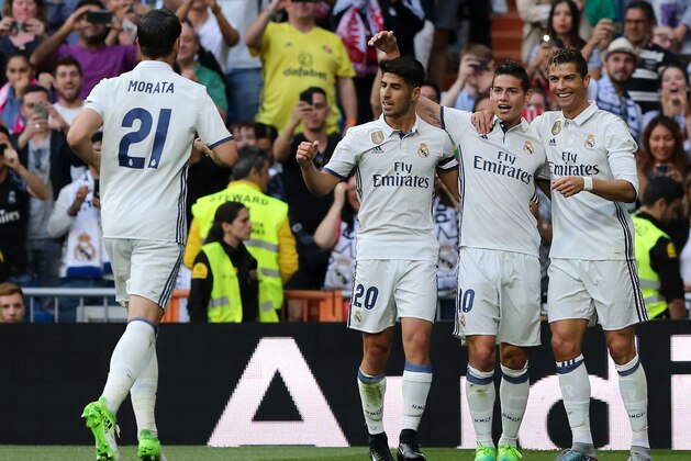 Real Madrid's Portuguese forward Cristiano Ronaldo (R) celebrates a goal with Real Madrid's Colombian midfielder James Rodriguez (2R) and Real Madrid's midfielder Marco Asensio (3R) during the Spanish league football match Real Madrid CF vs Sevilla FC at the Santiago Bernabeu stadium in Madrid on May 14, 2017. / AFP PHOTO / CESAR MANSO        (Photo credit should read CESAR MANSO/AFP/Getty Images)