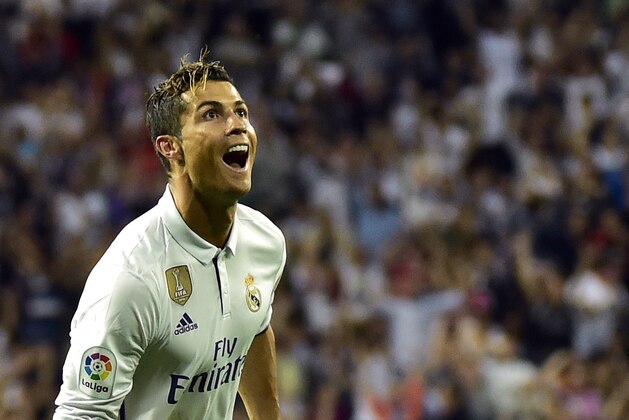 Real Madrid's Portuguese forward Cristiano Ronaldo celebrates after scoring during the Spanish league football match Real Madrid CF vs Sevilla FC at the Santiago Bernabeu stadium in Madrid on May 14, 2017. / AFP PHOTO / GERARD JULIEN        (Photo credit should read GERARD JULIEN/AFP/Getty Images)