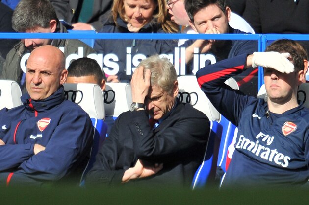 Arsenal's French manager Arsene Wenger (C) puts his hand on his head as he watches from the dug out during the English Premier League football match between Chelsea and Arsenal at Stamford Bridge in London on March 22, 2014. Chelsea won 6-0. AFP PHOTO / GLYN KIRK

RESTRICTED TO EDITORIAL USE. No use with unauthorized audio, video, data, fixture lists, club/league logos or live services. Online in-match use limited to 45 images, no video emulation. No use in betting, games or single club/league/player publications.        (Photo credit should read GLYN KIRK/AFP/Getty Images)