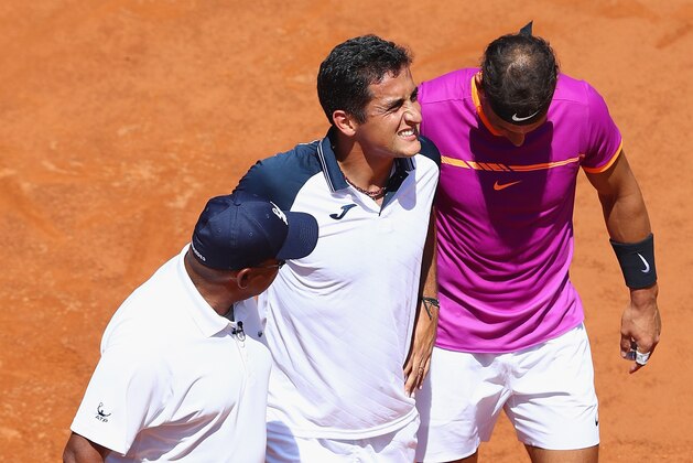 ROME, ITALY - MAY 17:  Nicolas Almagro (C) of Spain is helped off court by Rafael Nadal (R) of Spain and umpire Carlos Bernardes (L) after retiring at 0-3 in the opening set on Day Four of The Internazionali BNL d'Italia 2017 at the Foro Italico on May 17, 2017 in Rome, Italy.  (Photo by Michael Steele/Getty Images)