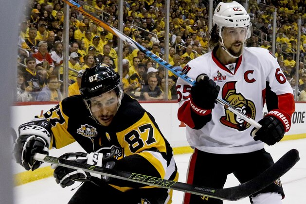 Ottawa Senators' Erik Karlsson (65) and Pittsburgh Penguins' Sidney Crosby (87) skate into the corner during the second period of Game 2 of the Eastern Conference final against the Pittsburgh Penguins in the NHL Stanley Cup hockey playoffs in Pittsburgh, Tuesday, May 16, 2017. (AP Photo/Gene J. Puskar)