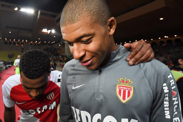 Monaco's French midfielder  Thomas Lemar (L) and foward Kylian Mbappe Lottin celebrate their victory at the end of the French L1 football match between Monaco (ASM) and Lille (LOSC) at the Louis II Stadium in Monaco on May 14,2017. / AFP PHOTO / Yann COATSALIOU        (Photo credit should read YANN COATSALIOU/AFP/Getty Images)