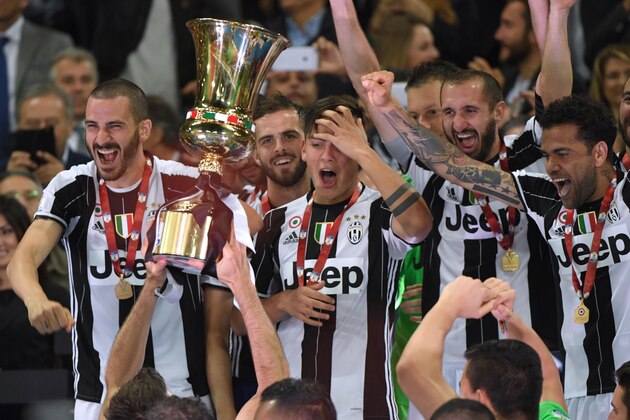 Juventus' players (from left) Juventus' defender from Italy Leonardo Bonucci, Juventus midfielder Miralem Pjanic, Juventus' forward from Argentina Paulo Dybala, Juventus' defender from Italy Giorgio Chiellini and Juventus Defender from Brazil Dani Alves celebrate with the trophy after winning the Italian Tim Cup final on May 17, 2017 at the Olympic stadium in Rome. Dani Alves and Leonardo Bonucci struck one apiece as treble-chasing Juventus secured a third successive Italian Cup with a 2-0 victory over Lazio at the Stadio Olimpico today.


Juventus, who won a league and Cup double the past two seasons, can clinch a record sixth consecutive Serie A title -- and a record third successive double -- with victory at home to Crotone in their penultimate Serie A game of the season on Sunday.
 / AFP PHOTO / Andreas SOLARO        (Photo credit should read ANDREAS SOLARO/AFP/Getty Images)