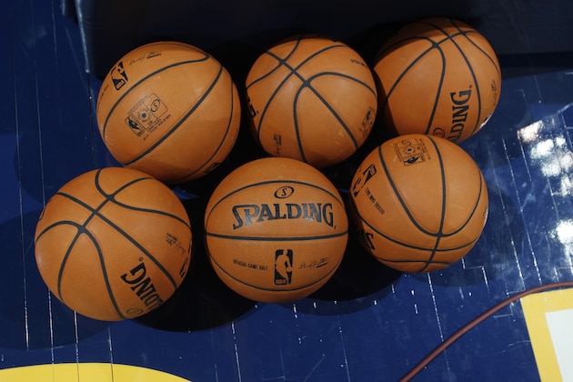 Spalding basketballs sit on court for use by the San Antonio Spurs as they face the Denver Nuggets in the first quarter of the Nuggets' 98-94 victory in an NBA preseason basketball game in Denver on Monday, Oct. 14, 2013. (AP Photo/David Zalubowski)