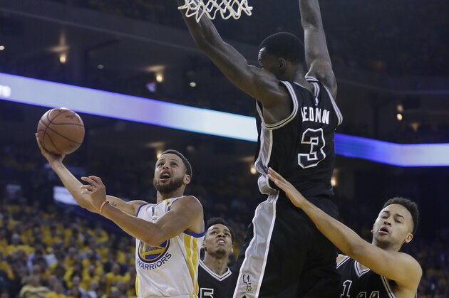 Golden State Warriors' Stephen Curry, left, drives past San Antonio Spurs' Dewayne Dedmon (3) and Kyle Anderson (1) during the first half of Game 2 of the NBA basketball Western Conference finals, Tuesday, May 16, 2017, in Oakland, Calif. (AP Photo/Marcio Jose Sanchez)