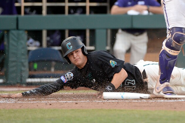 Jun 24, 2016; Omaha, NE, USA; Coastal Carolina Chanticleers outfielder Billy Cooke (17) slides under TCU Horned Frogs catcher Evan Skoug (9) for the first run of the game in the third inning in the 2016 College World Series at TD Ameritrade Park. Mandatory Credit: Steven Branscombe-USA TODAY Sports