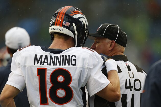 Denver Broncos quarterback Peyton Manning talks with umpire Butch Hannah before the start of a preseason NFL football game against the Seattle Seahawks, Friday, Aug. 14, 2015, in Seattle. (AP Photo/John Froschauer)