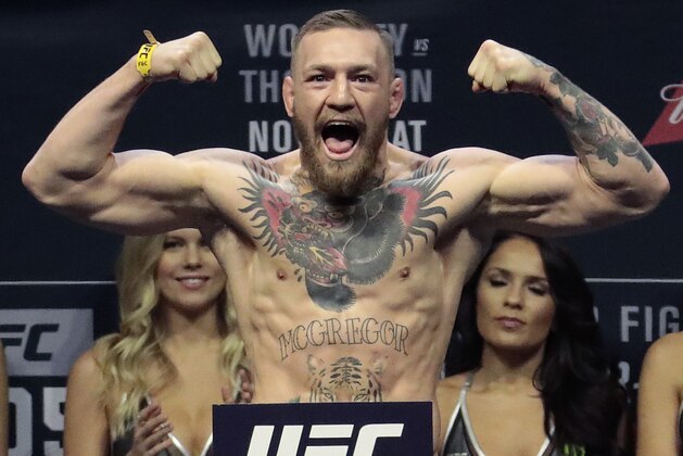 FILE - In this Friday, Nov. 11, 2016, file photo, Conor McGregor stands on a scale during the weigh-in event for his fight against Eddie Alvarez in UFC 205 mixed martial arts at Madison Square Garden in New York. (AP Photo/Julio Cortez, File)